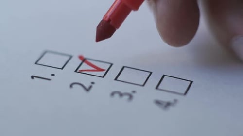 Cropped of Businesswoman Writing on Checklist