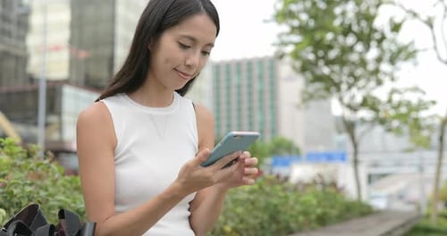 Woman Using Smartphone in Urban Park Setting
