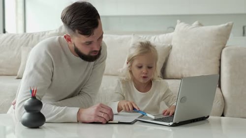 Father and Child Using Laptop Together at Home