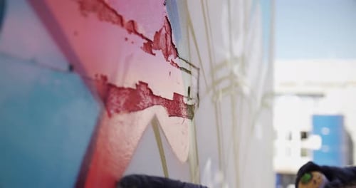 Graffiti-Künstler berührt die bemalte Wand 4k