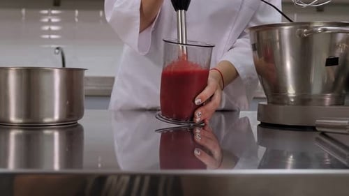 Person Blending Red Liquid in Commercial Kitchen