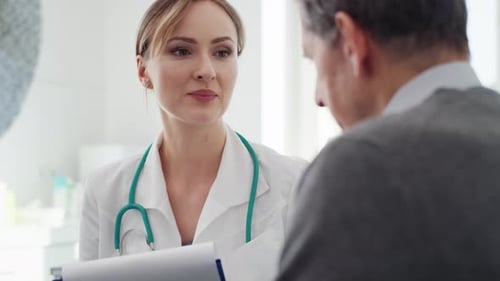 Handheld view of senior man and doctor in doctor’s office. Shot with RED helium camera