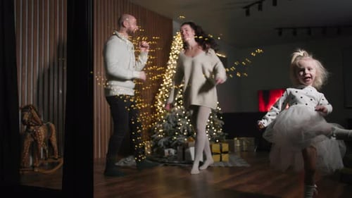 Family Dancing Together at Christmas Time in Home