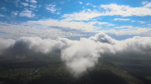 Aerial View From Airplane Window at High Altitude of Earth Covered with White Puffy Cumulus Clouds