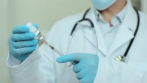 Doctor Filling Syringe with Vaccine in Hospital