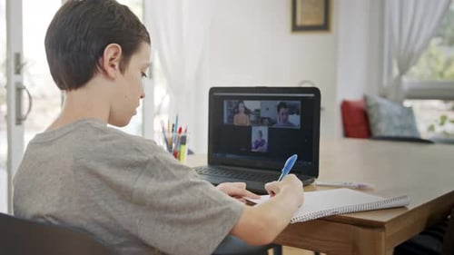 Teen Engaged in a Video Call While Writing