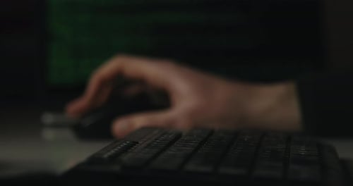 Hacker tippt Tasten auf einer Tastatur in seinem Zimmer