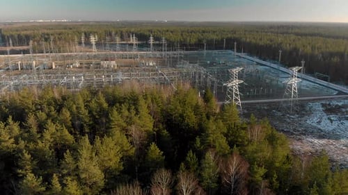 Electric Power Station with Power Lines in a Picturesque Coniferous Forest on a Sunny Winter Day