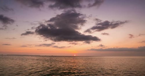 Zeitraffer: Sonnenuntergang über dem tropischen Meer bunter dramatisch Himmel bewegte Wolken. Kei ist