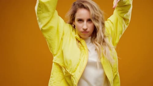 Woman Professional Dancer Dancing in Studio Against Yellow Background
