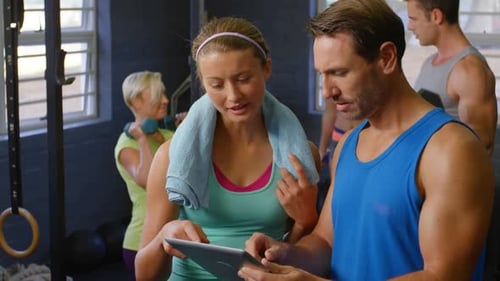 People Working Out at the Gym Using Tablet