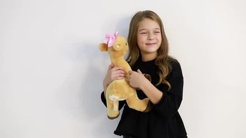 Happy Girl Hugs Stuffed Deer Toy Indoors