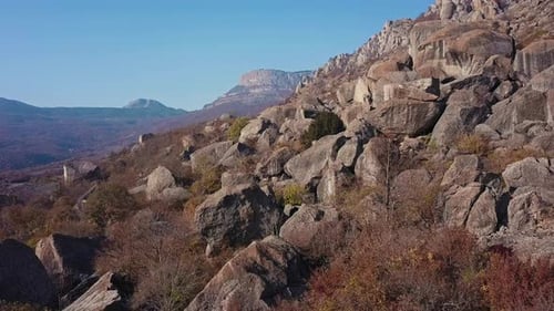 Fly Over Rocky Outcrop in Autumn Mountains