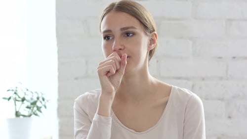 Young Adult Woman Coughing Indoors