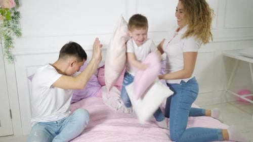 Family Having a Pillow Fight in Bedroom