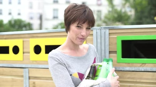 Mujer que lleva botellas de plástico en el centro de reciclaje