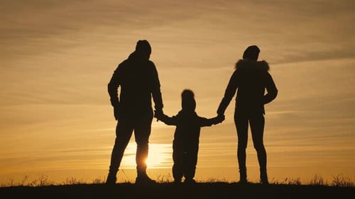 Family Holding Hands at Picturesque Golden Sunset