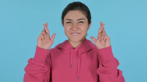 Smiling Woman Crossing Fingers Hoping for Good Luck
