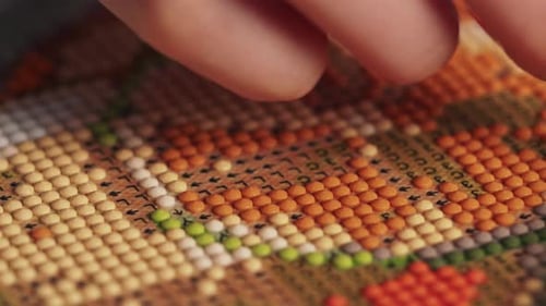 Primer plano de niña pone un cuadro con cuentas