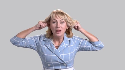 Lustige reife Frau auf grauem Hintergrund.