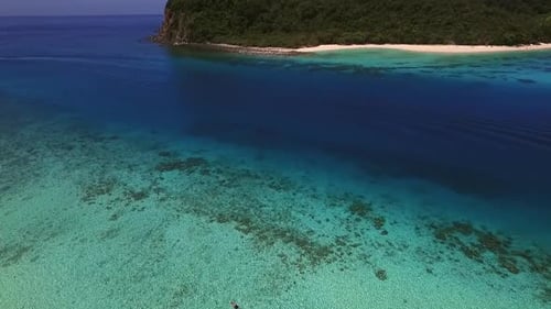 Aerial view of a man swimming alone on the paradisiacal beach on Koh Rok Yai island.