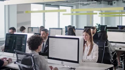 Espace ouvert de bureau d'entreprise moderne avec un groupe d'employés occupés multiculturels utilisant des ordinateurs PC