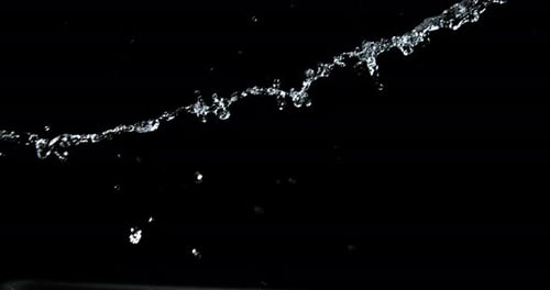 L'eau explose et éclabousse sur fond noir, ralenti 4K