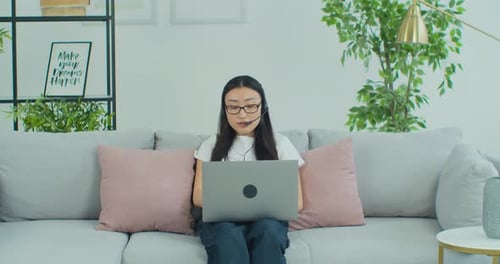 Young Woman Working Remotely from Home on Laptop