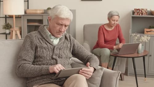 Mature Man Using Tablet Device in a Bright Living Room