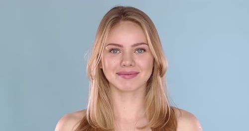 Potrait of Beautiful Blond Woman with Long Hair, Posing in Studio on Blue Background