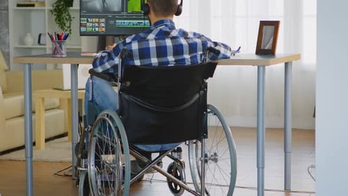 Man in Wheelchair Working on Computer Indoors
