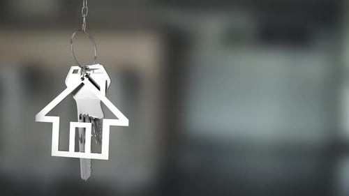Las llaves de la casa y el llavero cuelgan sobre un fondo desenfocado 4k