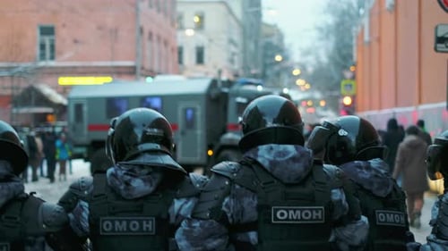 Les unités de la police anti-émeute en offensive contre les personnes se rassemblent sous des lumières clignot