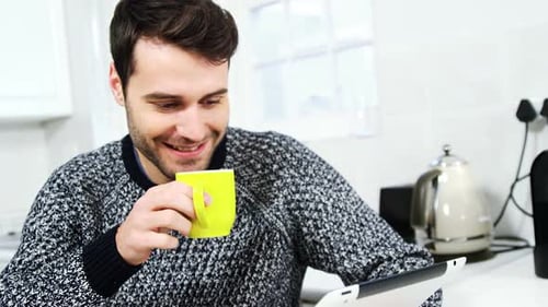 Man Enjoys Tablet and Coffee in Kitchen