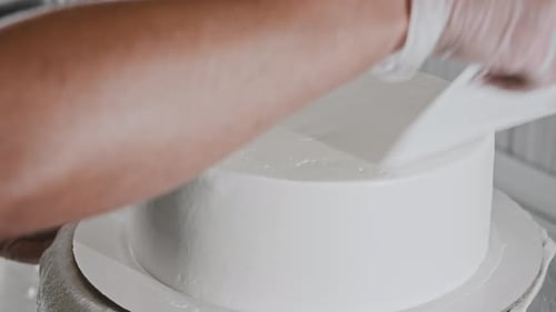 Cake Decorating with White Frosting in Professional Kitchen