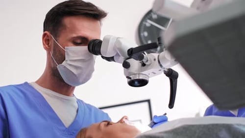 Dentist Using Microscope During Dental Procedure