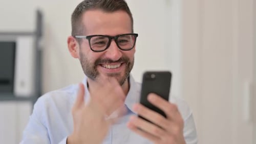 Man Celebrates Success Using Mobile Phone