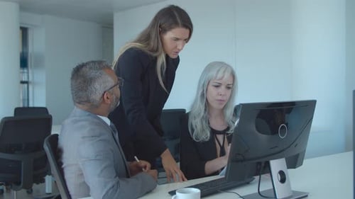 Kollegen verfolgen und diskutieren Präsentation auf dem Monitor
