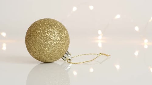 Slow tilt on Christmas tree ornament with shiny fairy lights 4K 2160p 30fps UltraHD footage - Golden