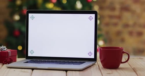 Video of wooden table with laptop over christmas tree