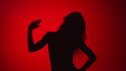 Woman Dancing Silhouette Against Red Background