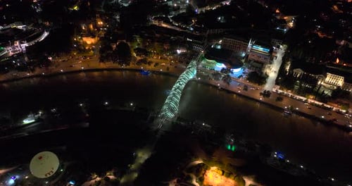Night aerial view of Bridge of Peace and beautiful cityscape in the center of Tbilisi, Georgia 2022