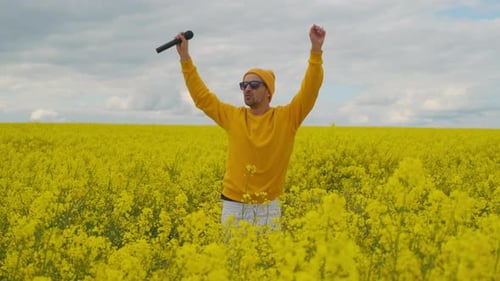 Energetic Man Sings in Blooming Yellow Flower Field