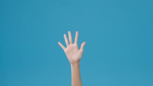 Hand Waving Against Light Blue Background