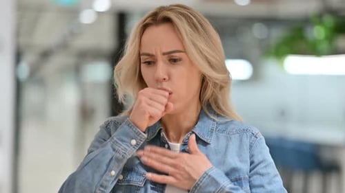 Blonde Woman Coughing Indoors During the Daytime