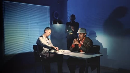 Intense Interrogation of Suspect with Officers in Dark Room