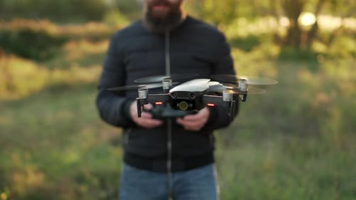 Adult Man Launching Drone in Grassy Field
