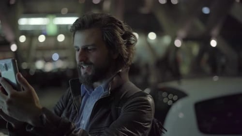 Caucasian Positive Man Having Video Chat on Smartphone in City