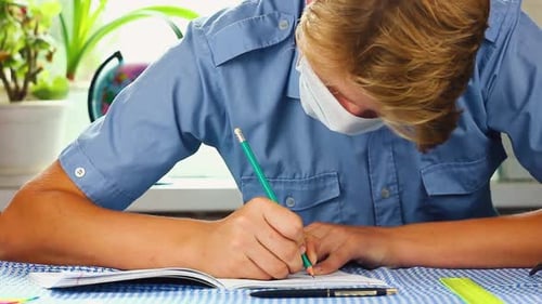 Student in Mask Doing Homework at Desk