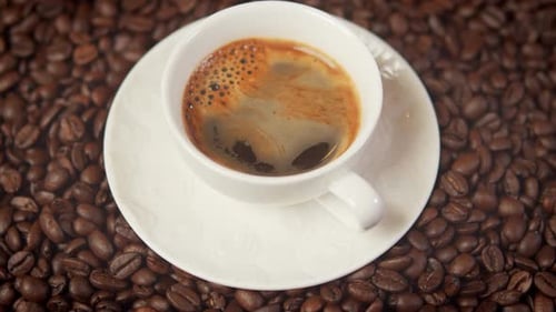 Close Up of Coffee in Cup on Coffee Beans